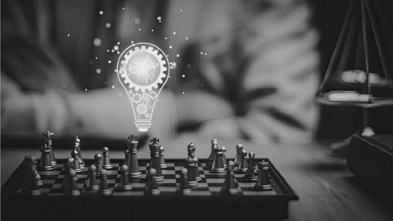 Schachbrett mit Schachfiguren und Lichtbirne, symbolisiert strategisches Denken und Innovation.